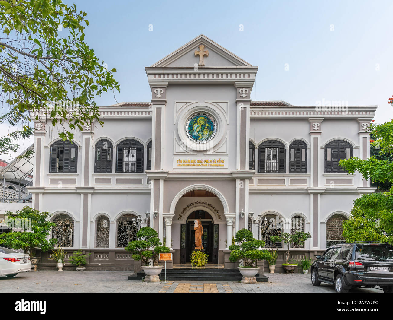 Da nang, Vietnam - 10 mars 2019 : maison de l'évêque catholique du diocèse sous ciel bleu et vert feuillage. Statue de Jésus le sheppa Banque D'Images