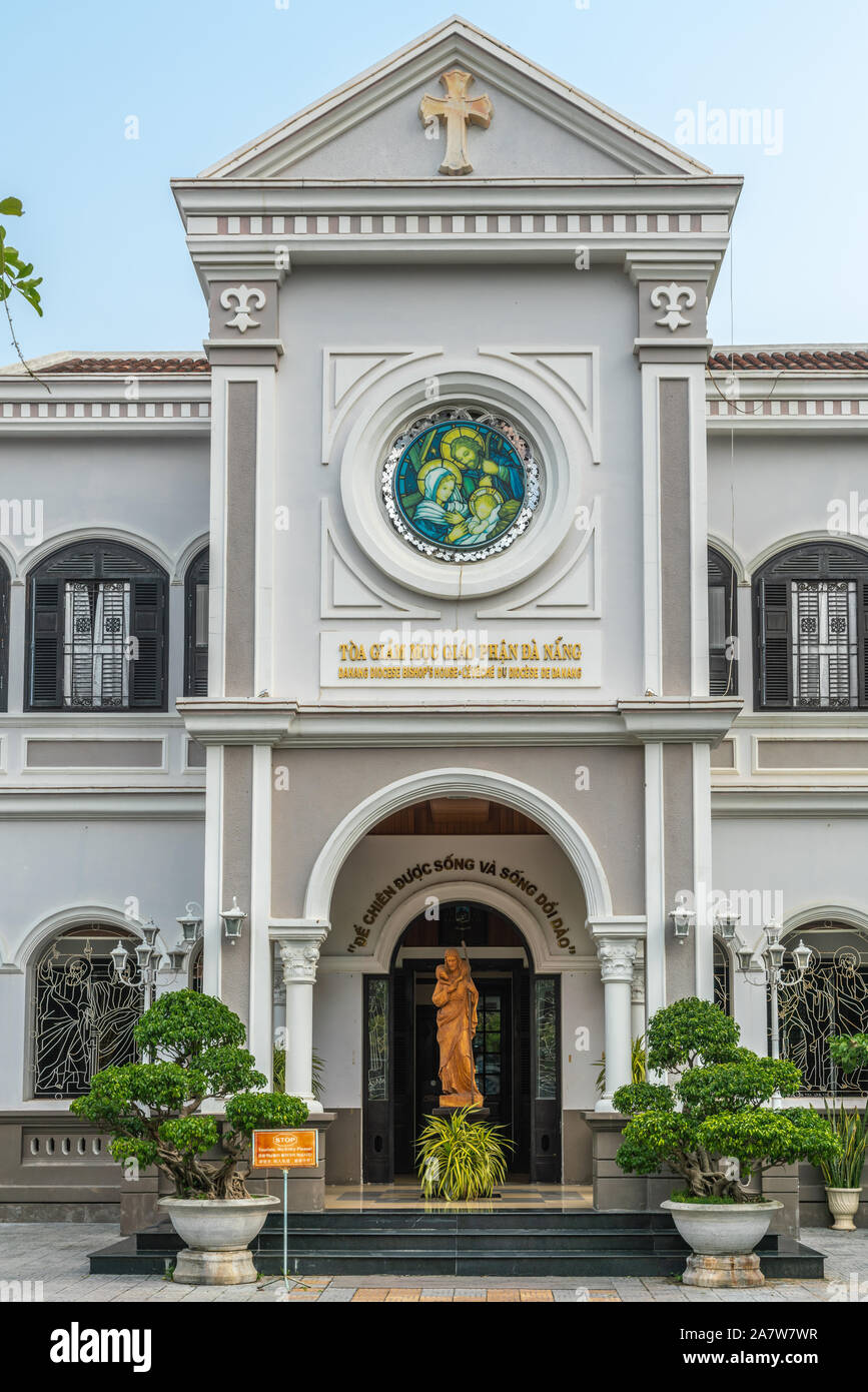 Da nang, Vietnam - 10 mars 2019 Entrée : Partie de maison grise de l'évêque catholique du diocèse sous ciel bleu et vert feuillage. Statue de Banque D'Images