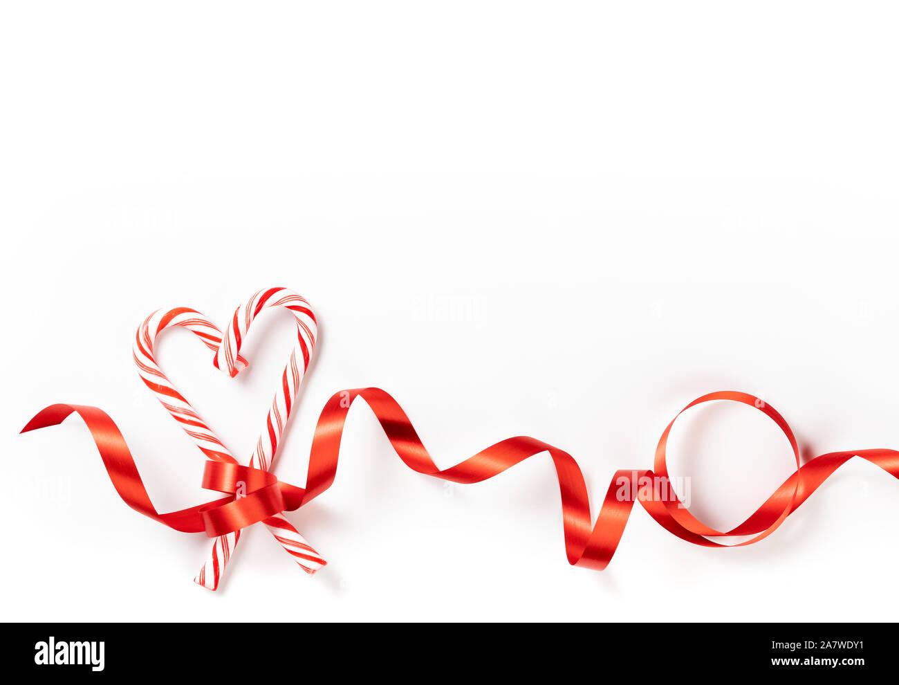 Canne de Noël coeur frontière avec ruban rouge sur fond blanc Banque D'Images