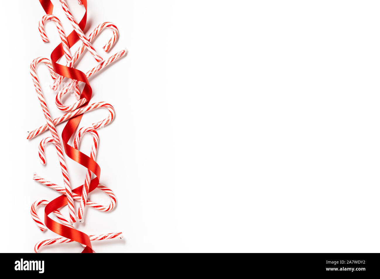 Canne de Noël frontière avec ruban rouge sur fond blanc Banque D'Images