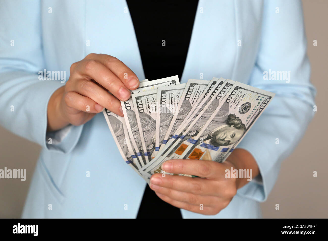 Femme en costume d'affaires en dollars US Holding Hands, close-up. Gestionnaire, officiel ou businesswoman compte le argent dans office, concept d'un salaire Banque D'Images