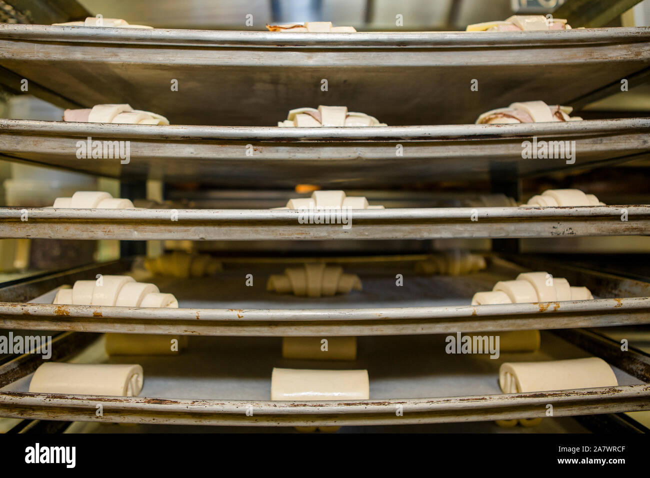 Des présentoirs de pâte non cuite assis sur des piles de feuilles de cookie Banque D'Images