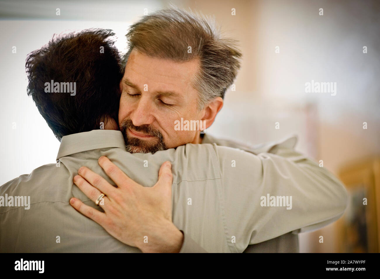 Mid-adult man hugging son partenaire. Banque D'Images