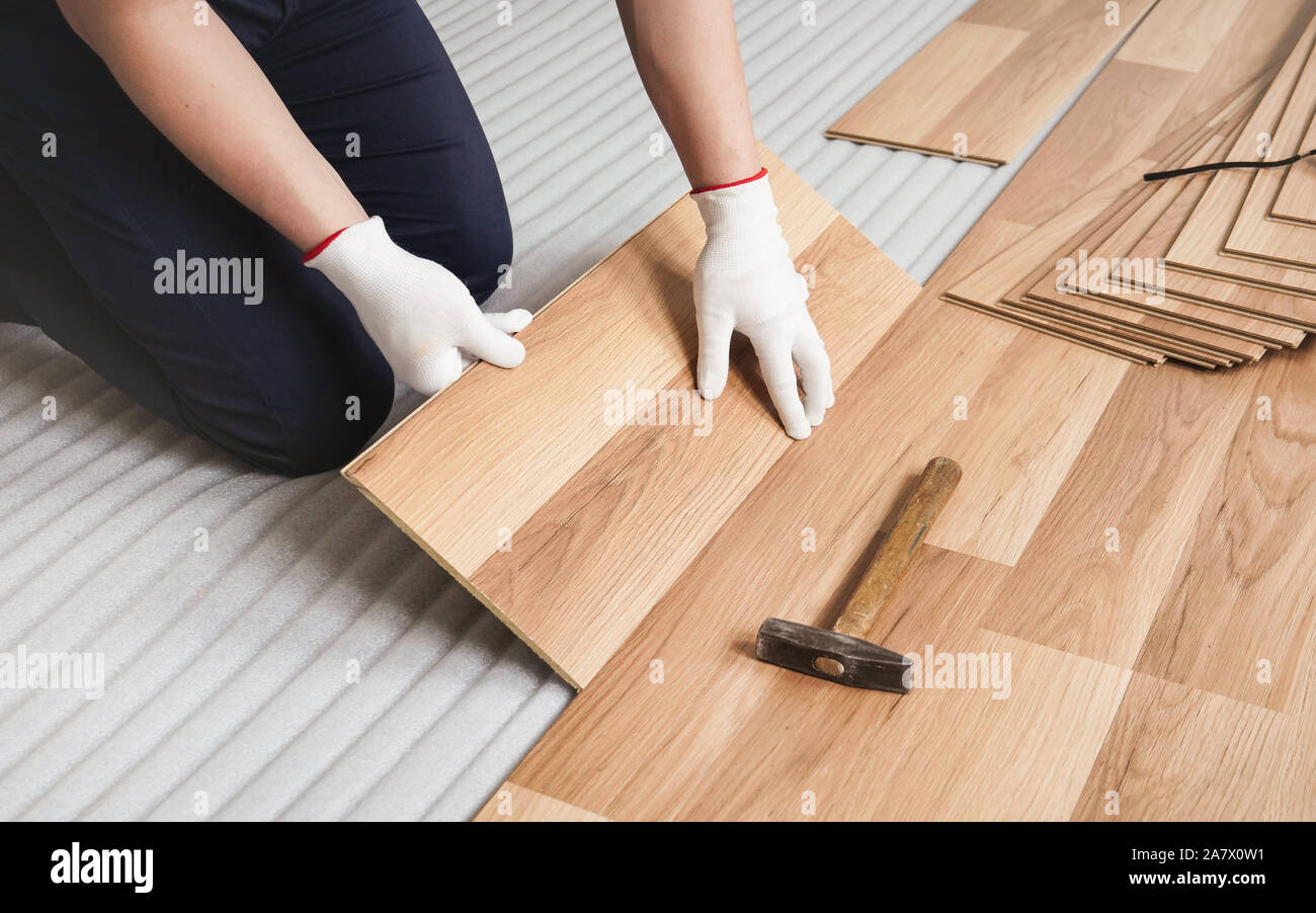 L'installation de l'homme, vue de détail sur le plancher stratifié  carrelage en bois en cours d'installation, plus de mousse blanche couche de  base Photo Stock - Alamy