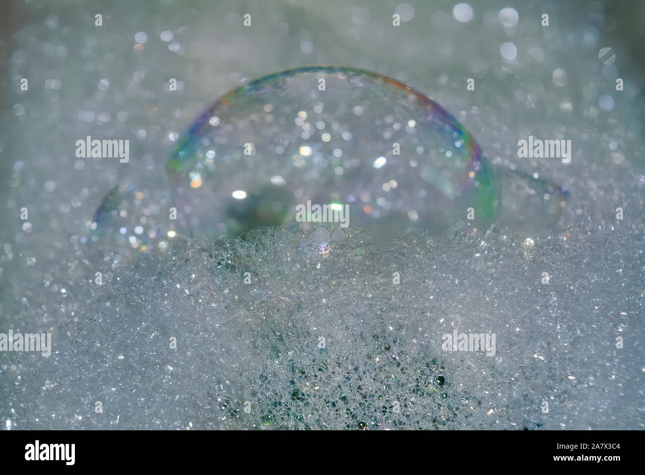 La texture de mousse savonneuse avec rainbow bubbles close-up. Mousse de savon sur la surface de l'eau. Banque D'Images
