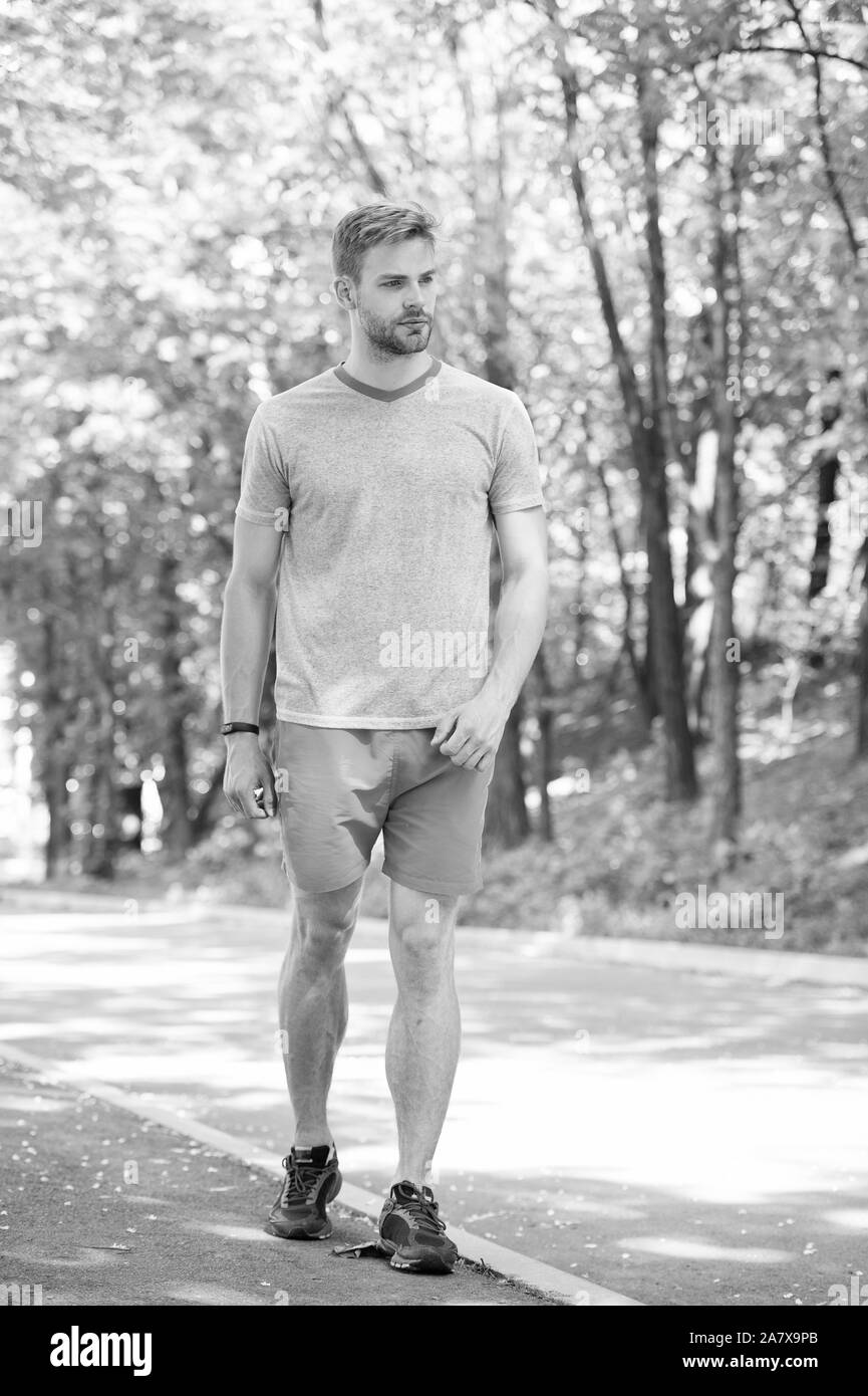 Sport de plein air de la formation. Bel homme dans le sport wear marche sur paysage naturel. La pratique du sport sportif sportifs activités sur journée d'été. Sport et fitness. Banque D'Images