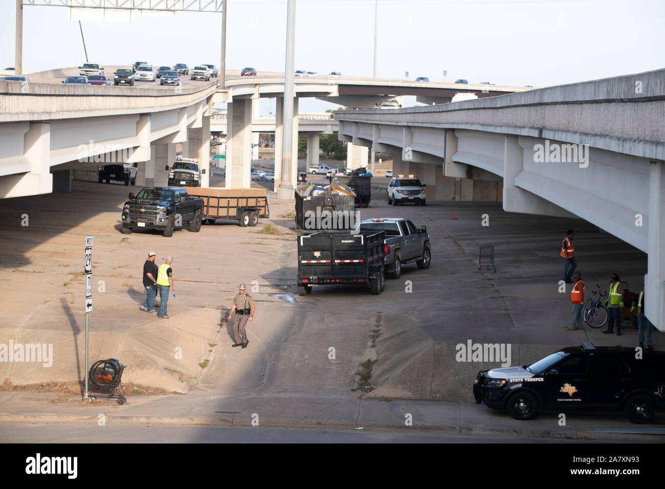 Les travailleurs de la Texas Highway Ministère terminer le nettoyage en place d'un campement de sans-abri sur l'emprise publique sous un viaduc à Austin Texas ordonne de Gov. Greg Abbott. Banque D'Images
