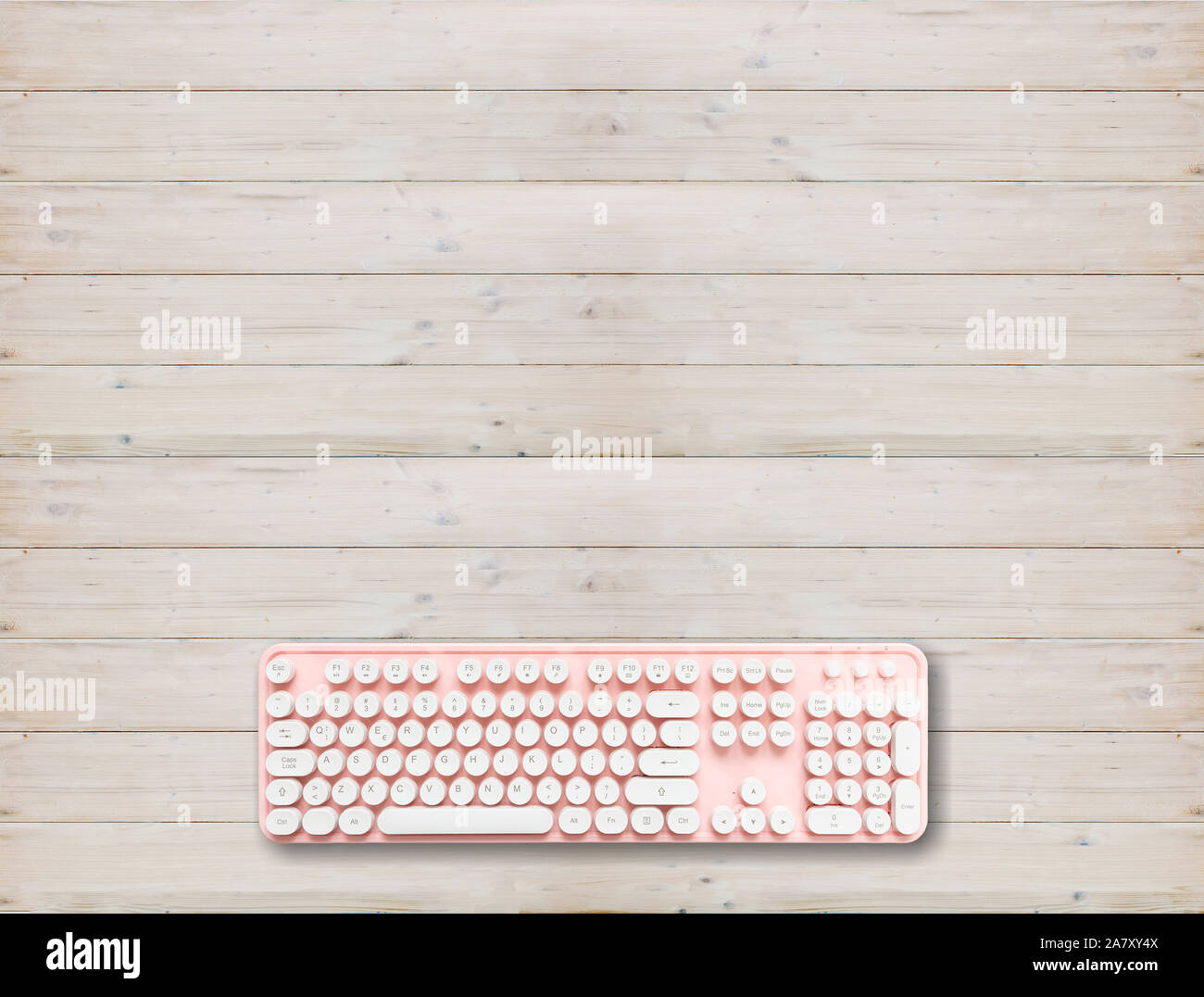 Clavier ordinateur rose avec boutons blancs contre fond de bois, copie espace, vue du dessus Banque D'Images