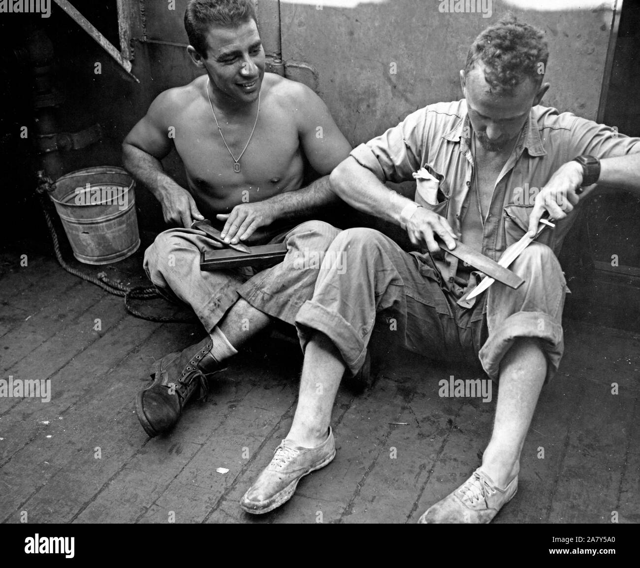 La Seconde Guerre mondiale photo - deux marines aiguiser leurs couteaux avant d'aller sur l'île de Tarawa Banque D'Images