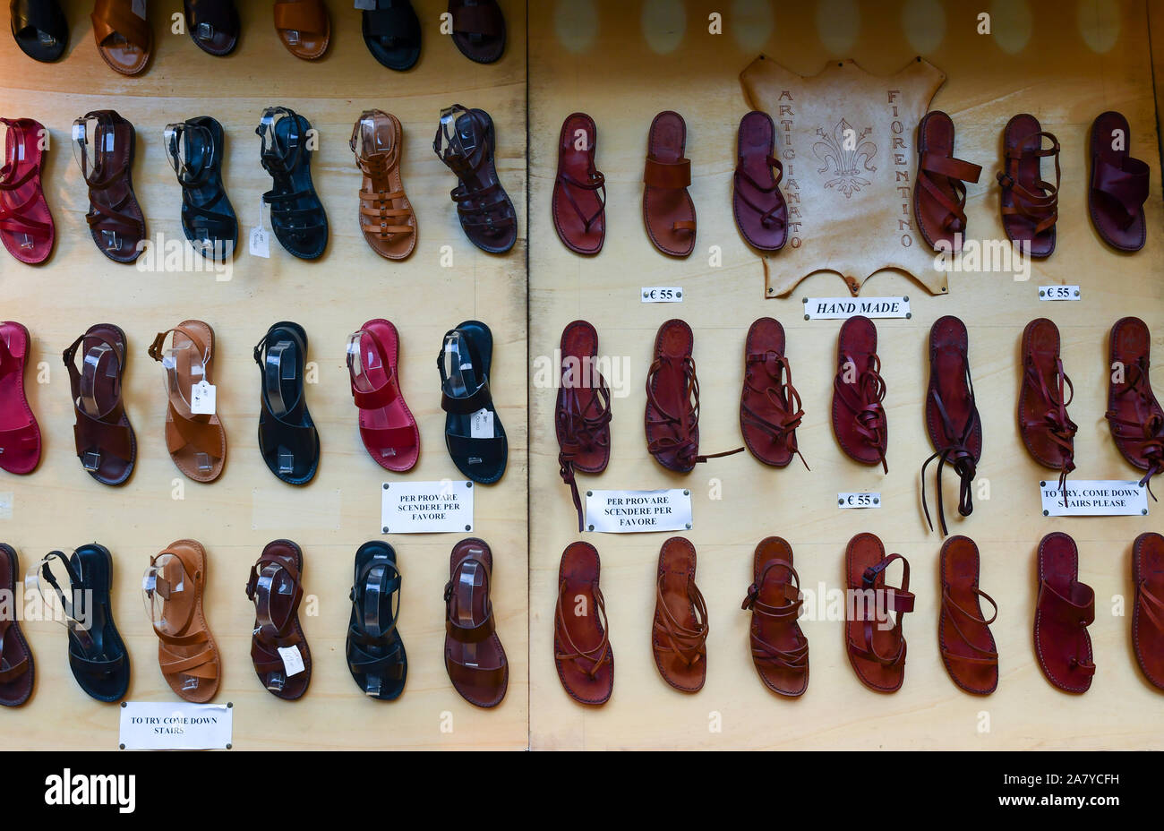 Rangées de sandales en cuir exposées sur le mur extérieur d'une boutique de produits en cuir dans le centre-ville de Florence, Toscane, Italie Banque D'Images