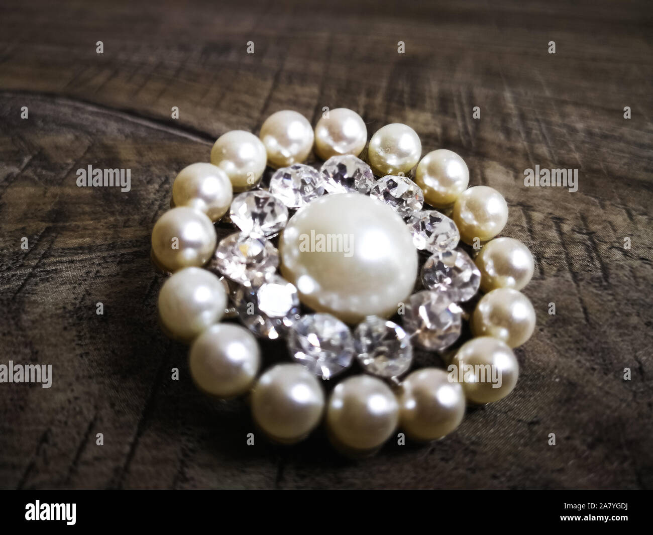 Broche avec perle blanche pour les vêtements isolé sur fond de bois.  Diamond Brooch avec pierre. Ancienne broche précieux Photo Stock - Alamy