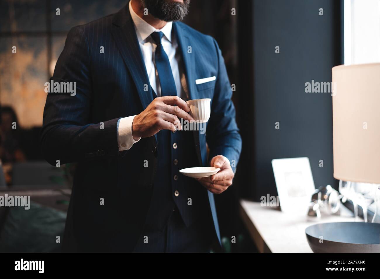 Homme confiant dans smart casual wear holding Coffee cup à son lieu de travail à l'office de tourisme Banque D'Images