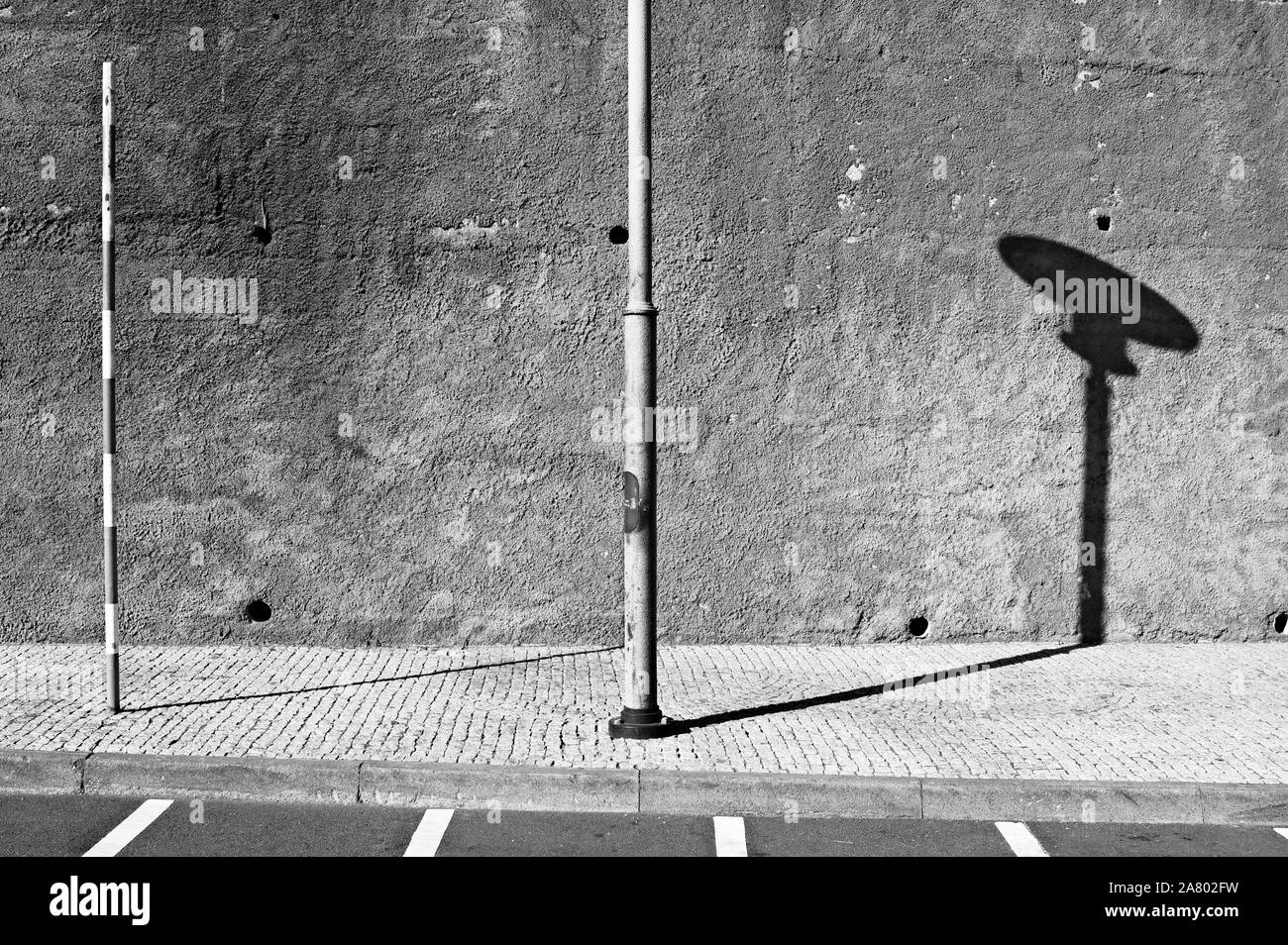 Pôle légères isolées dans le trottoir près de parking rangées sur une route pavée (Madère, Portugal, Europe) Banque D'Images