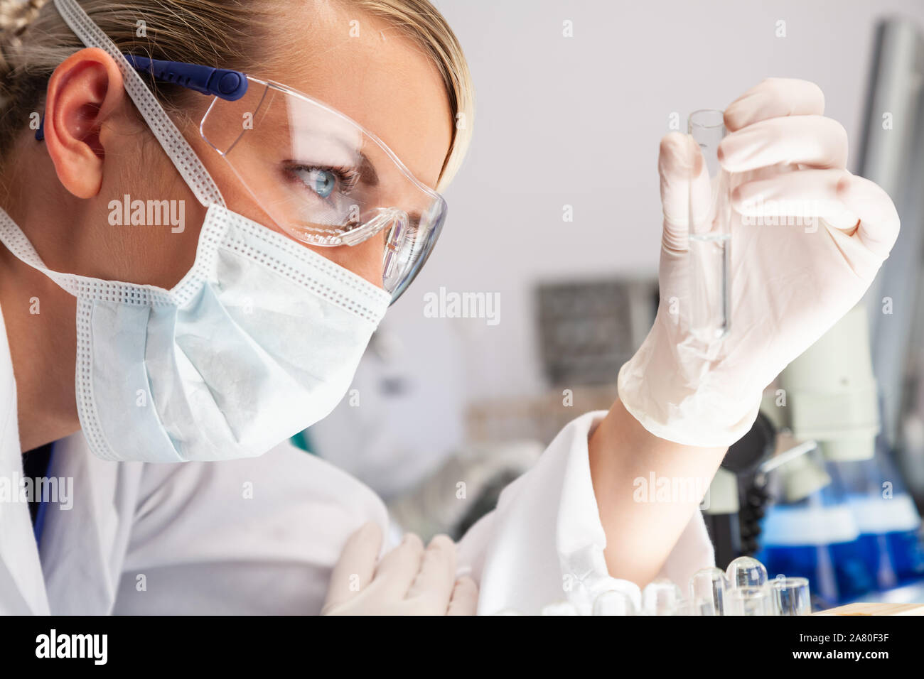 Chercheur scientifique ou médical féminin, femme scientifique ou un médecin travaillant à la recherche à un tube à essai de solution claire dans un laboratoire ou en laboratoire Banque D'Images