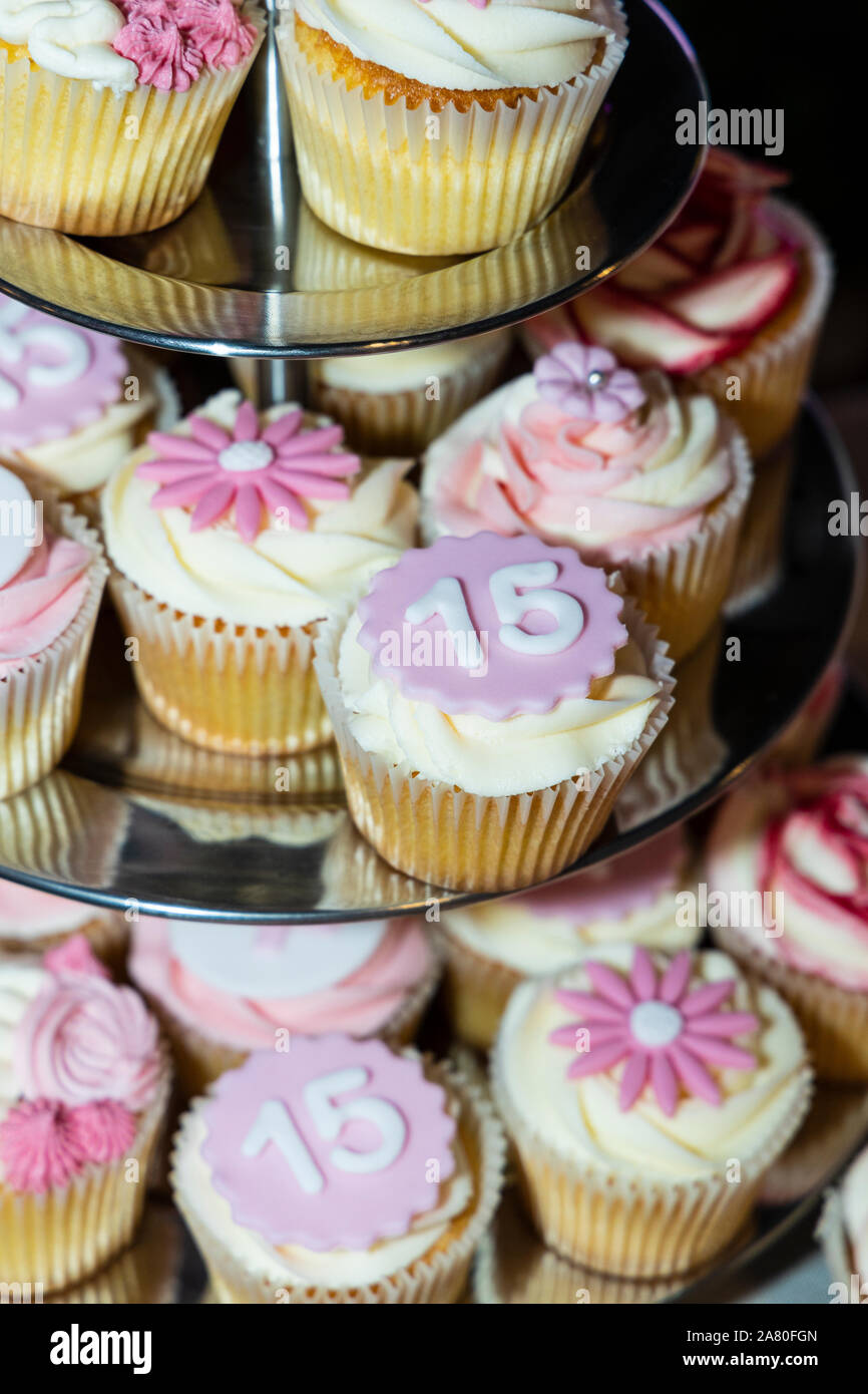Cupcakes sur un gâteau décoré de glaçage rose et nymber 15 pour un 15e anniversaire Banque D'Images