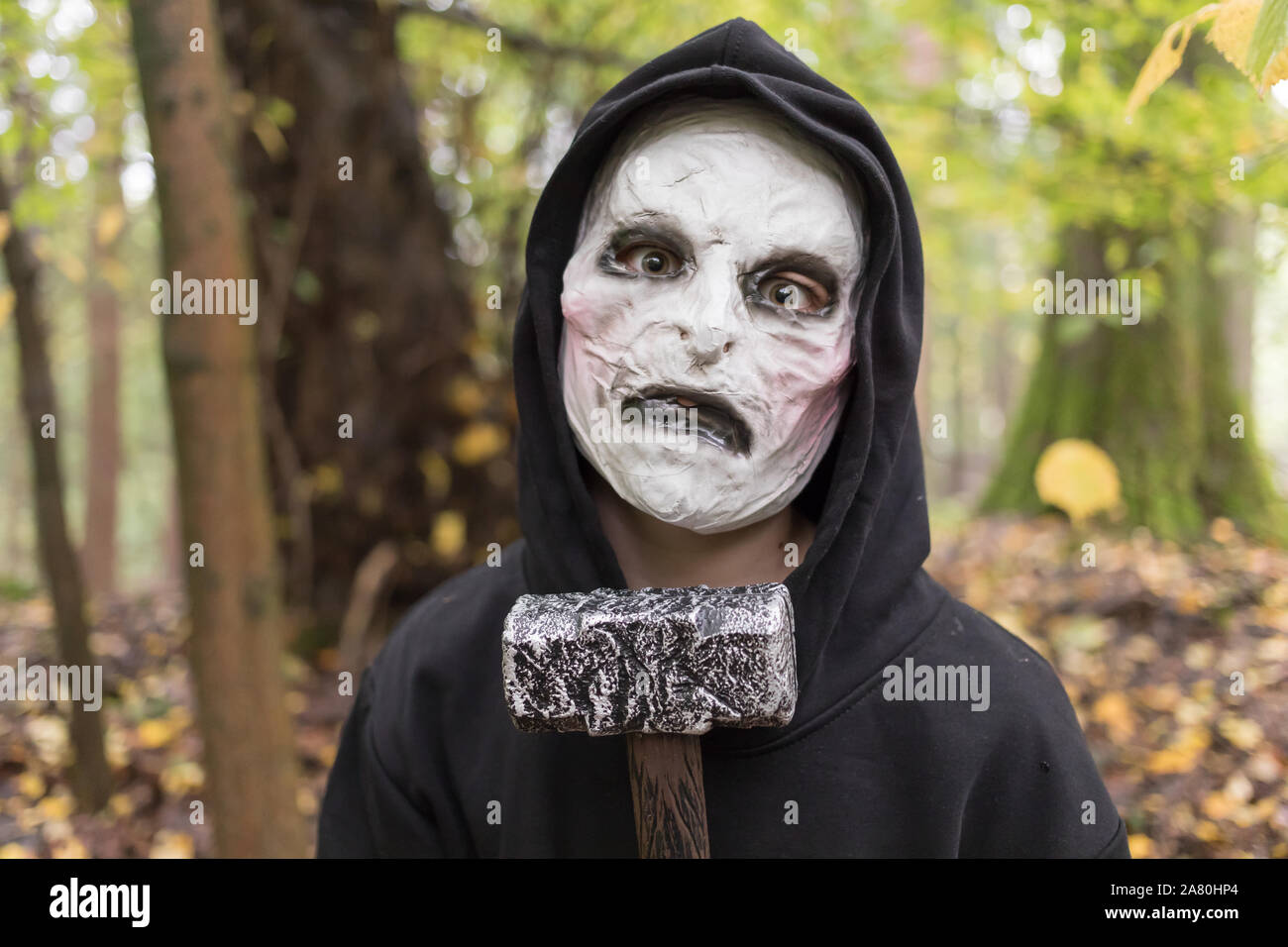 Adolescent avec masque halloween dans la forêt Banque D'Images