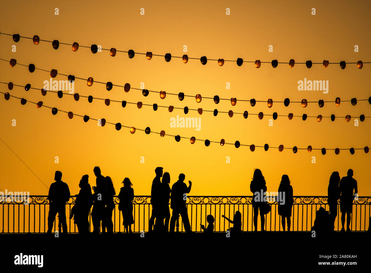 Piétons sur le pont de Triana pendant la Vela de Santa Ana festival, Séville, Espagne Banque D'Images