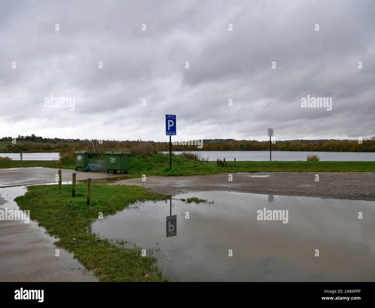 Réflexion d'un parking sign dans une flaque d'eau par le lac à Pugneys Country Park, à Wakefield Yorkshire Angleterre Banque D'Images