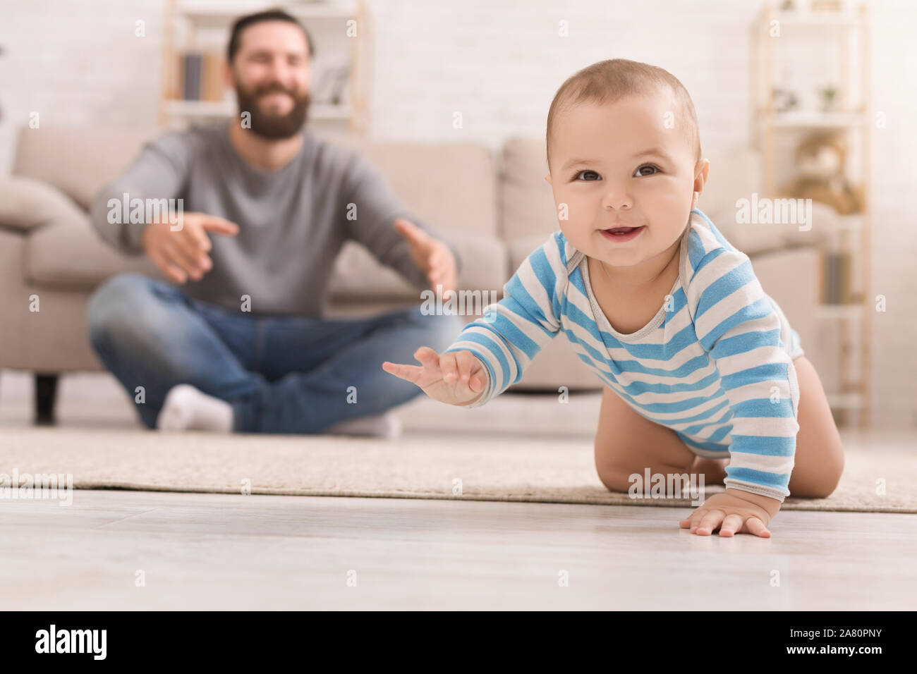 Adorable baby boy crawling sur marbre avec papa Banque D'Images