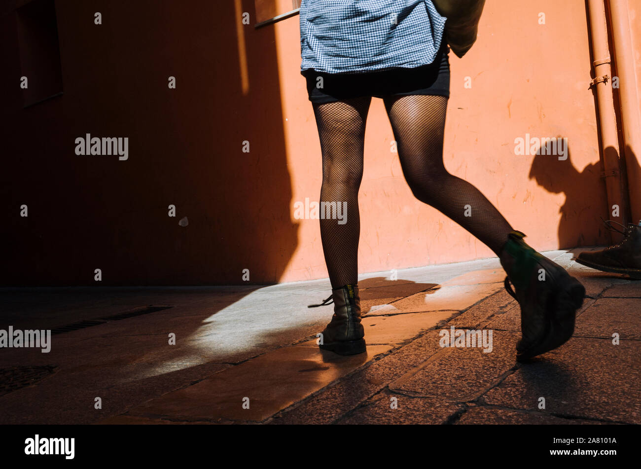 Granada : Détail des jambes d'une femme en bas noirs visiter les rues du centre historique de Grenade. Ombre et Lumière, scène de rue. Banque D'Images