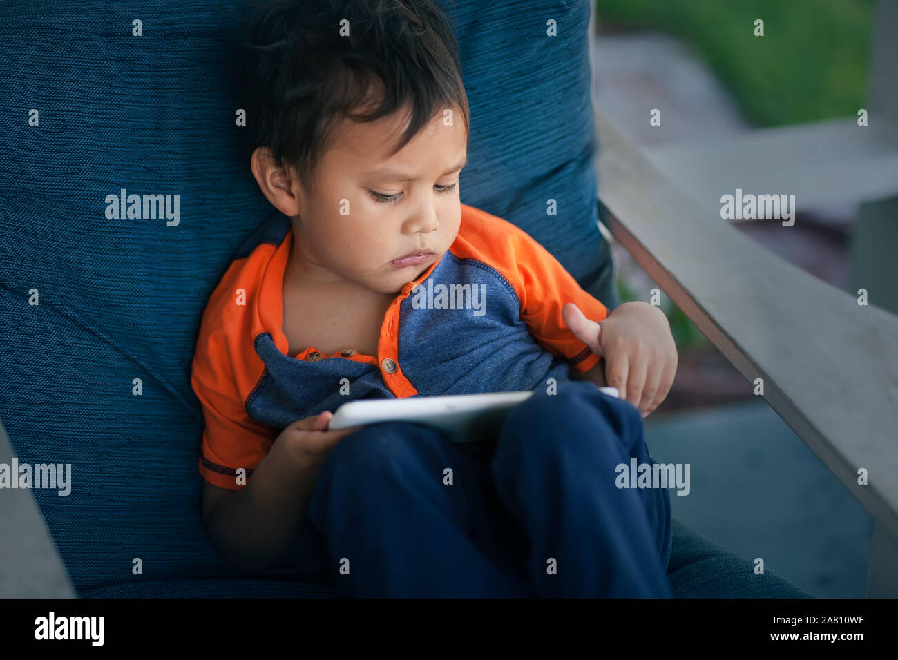 Un petit enfant naviguer sur le web sans contrôle parental et semble perturbé. Banque D'Images