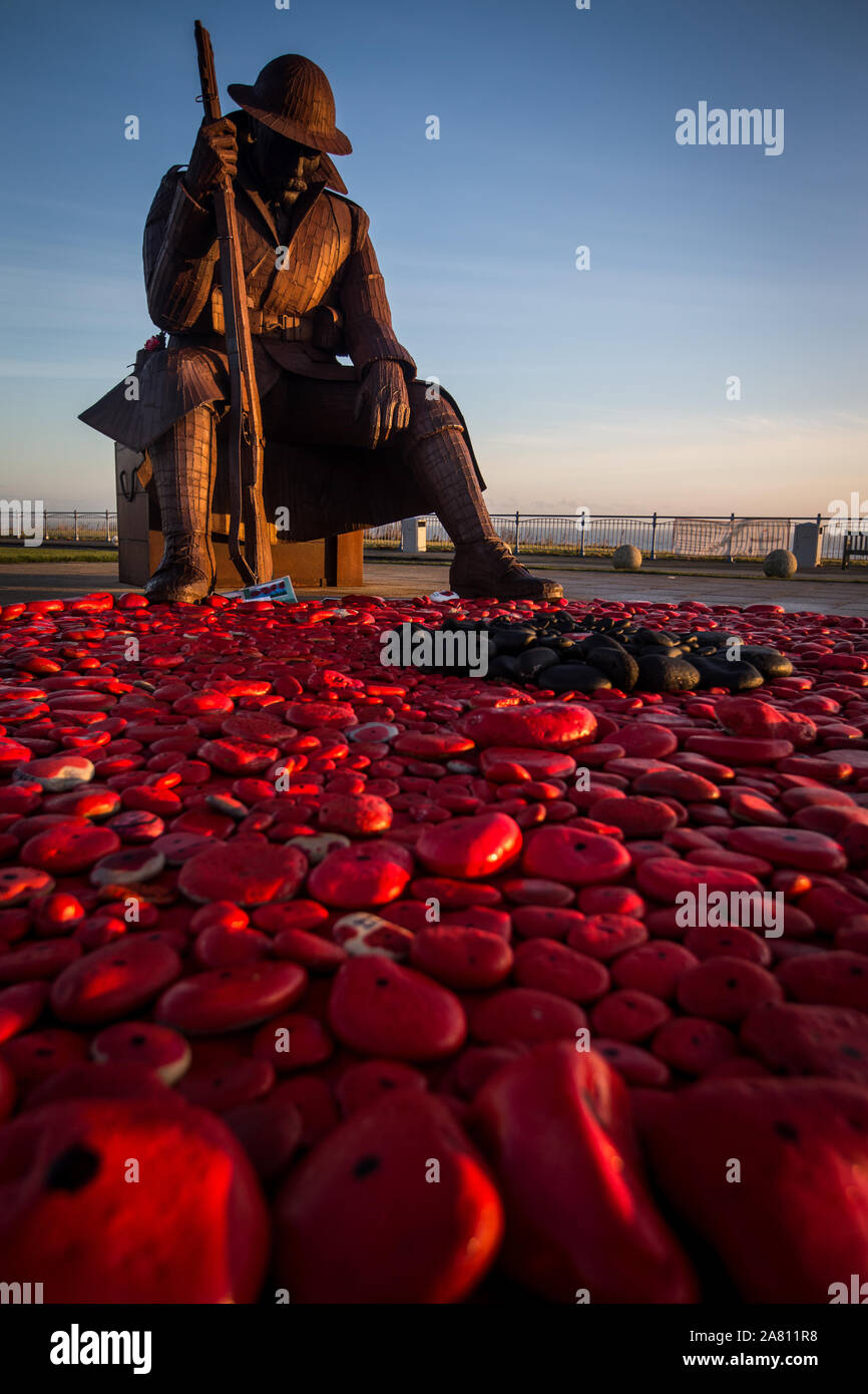 Lever de soleil à la Statue de Tommy le matin du jour du Souvenir à Seaham County Durham. Un service du souvenir aura lieu à la statue de se rappeler les soldats tombés.le mercredi 11 novembre 2015, County Durham, Angleterre. Un hommage à la tombée du jour du Souvenir de l'avant vendredi par le souvenir d'un Fonds du coquelicot géant, créé à l'aide de cailloux de la plage, peints en rouge et le mit aux pieds du 1101 (aka Tommy) statue, un neuf et demi pied sculpture d'un soldat fatigué par Ray Lonsdale.lever de soleil à la Statue de Tommy le matin du jour du Souvenir à Seaham County Durham. Un service Banque D'Images