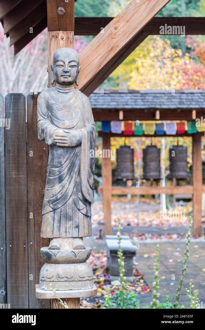 Statue de Bouddha avec des cloches et des couleurs de l'automne en arrière-plan Banque D'Images