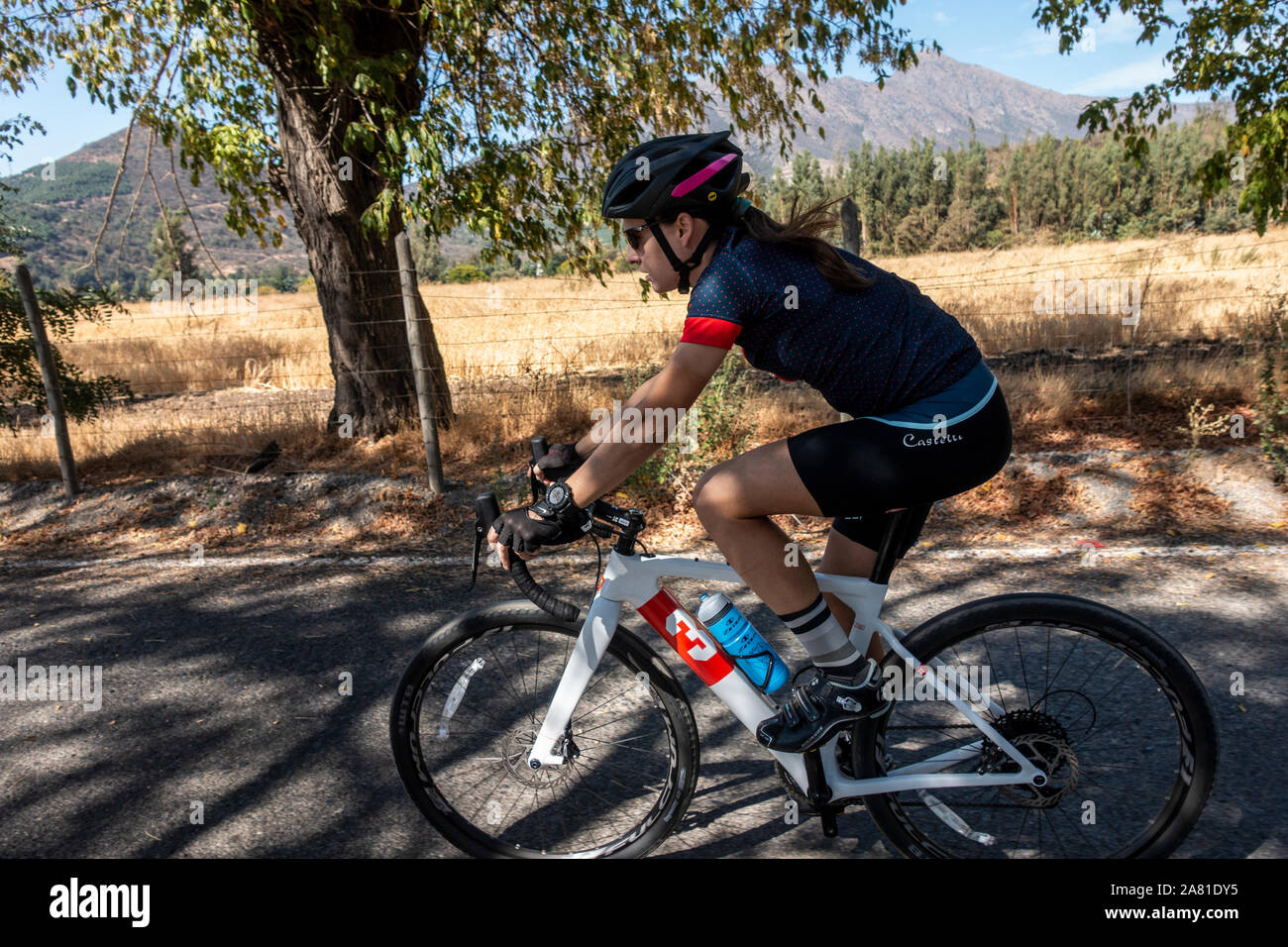 Cycliste féminine équitation un vélo sur la route de gravier. Banque D'Images