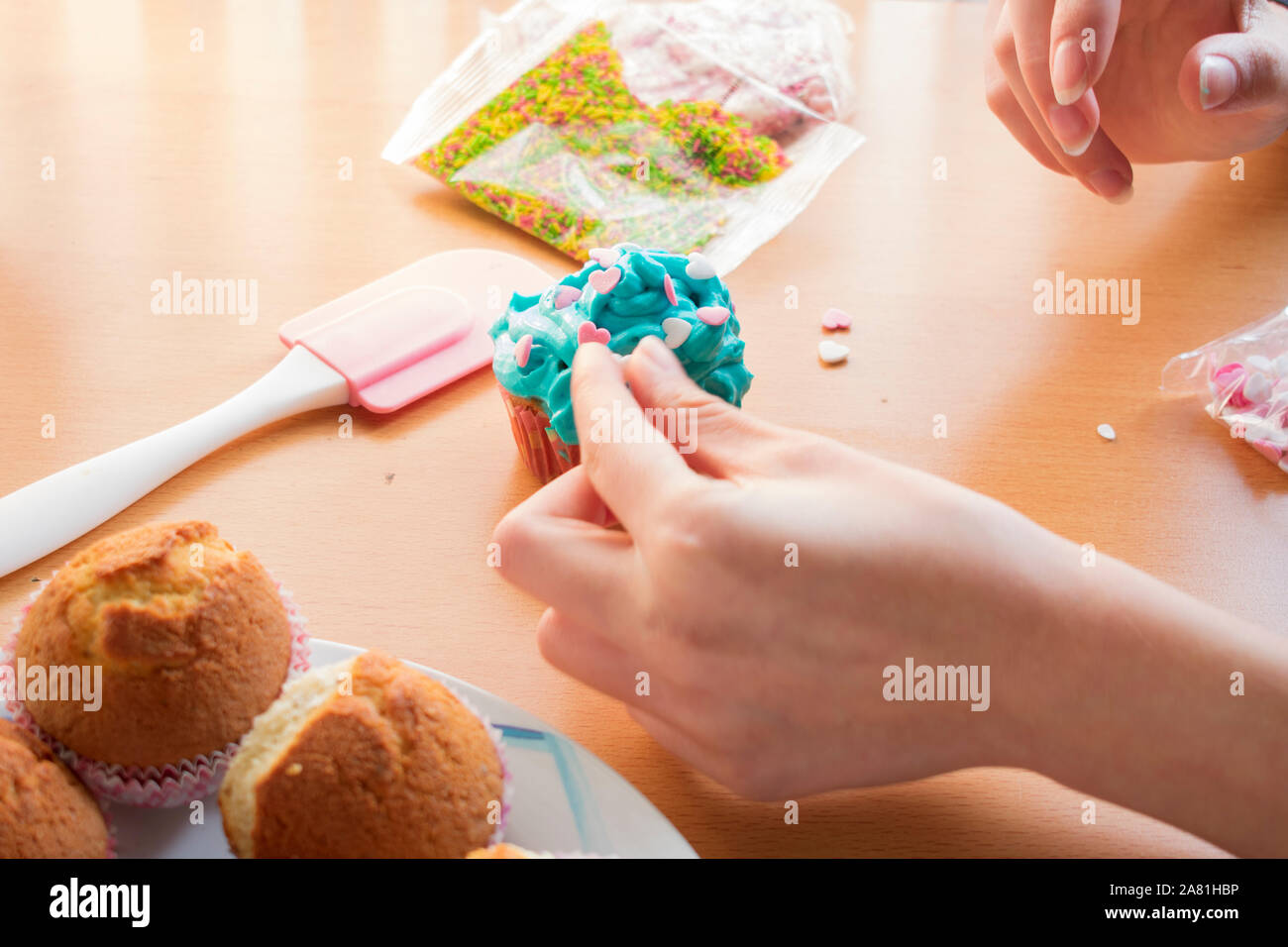 La décoration d'un des petits gâteaux avec des coeurs Banque D'Images La décoration d'un des petits gâteaux avec des coeurs Banque D'Images