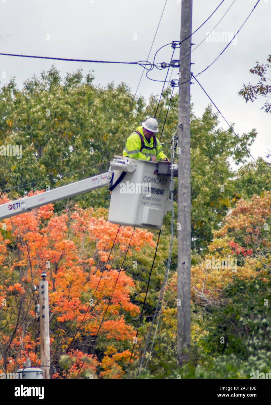 Un travailleur d'une tour d'ascenseur, des lignes de câble électrique et les réparations, après une forte tempête a fait des dommages dans le Michigan USA Banque D'Images