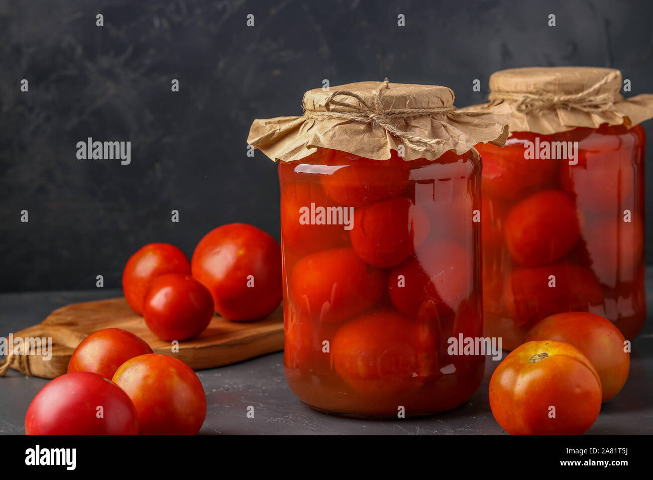 Des tomates salées en pots sur un fond sombre, les aliments fermentés, gros plan Banque D'Images