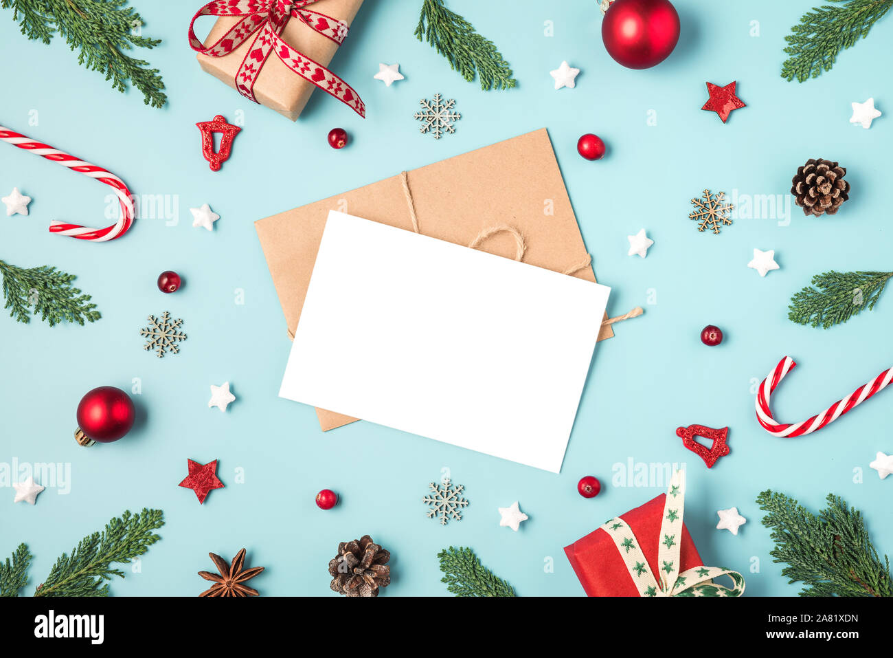 Carte de vœux de Noël à bâti fait de branches de sapins, des boîtes-cadeaux, des bonbons, des décorations de vacances rouge sur fond bleu. maquette. Télévision. Vue de dessus Banque D'Images