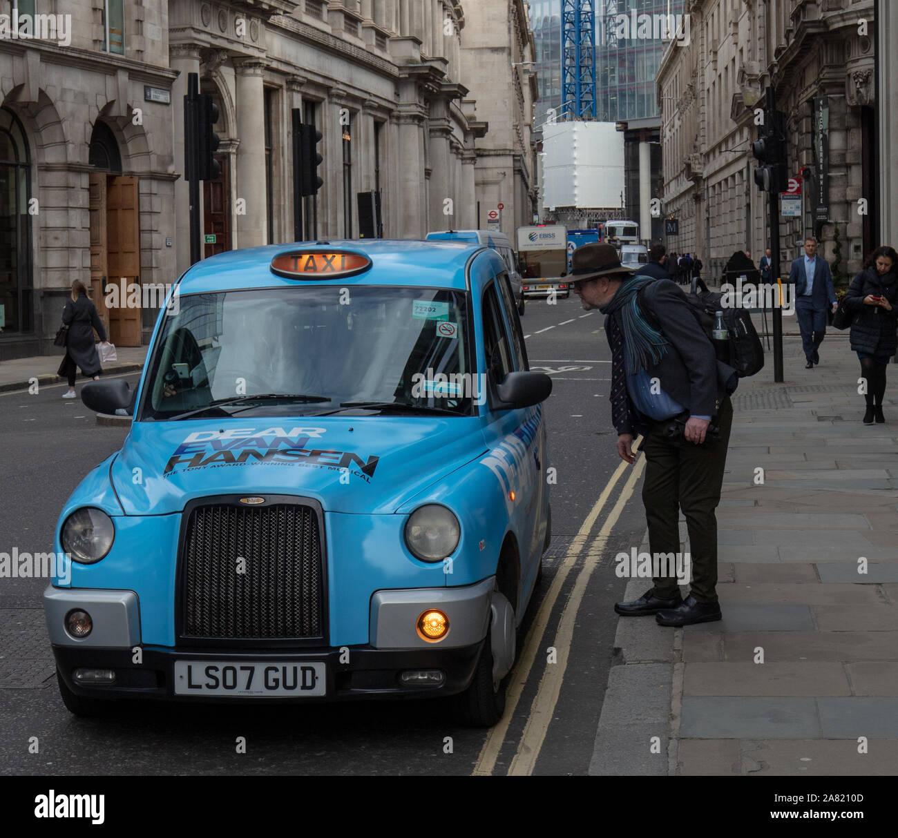 Vu les visiteurs prendre un taxi ou de Londres cabine dans la ville de Londres en novembre. Banque D'Images