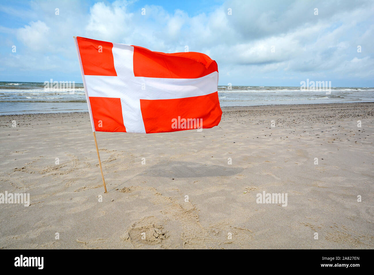 Drapeau danois dans le vent à la plage de sable près de Blavand, Jutland au Danemark Banque D'Images