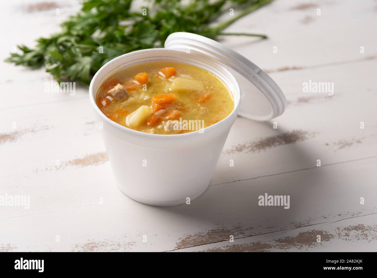 Soupe de légumes dans un bol en plastique jetables avec un couvercle, sur fond blanc. Concept de l'alimentation rapide et facile. Le comportement alimentaire, de la distribution. Banque D'Images
