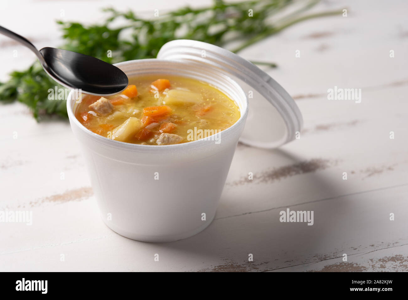 Soupe de légumes dans un bol en plastique jetables avec un couvercle, sur fond blanc. Concept de l'alimentation rapide et facile. Le comportement alimentaire, de la distribution. Banque D'Images