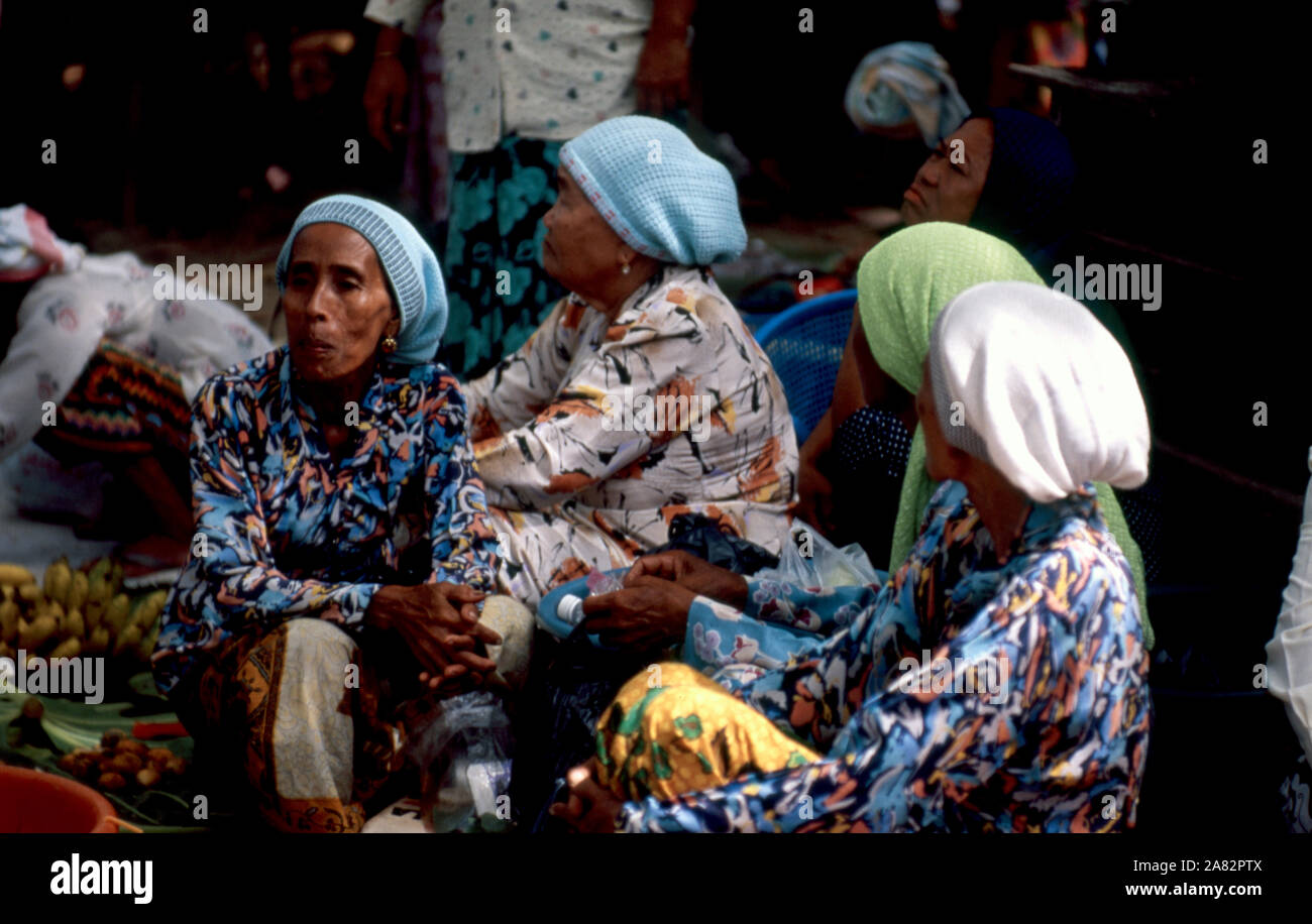 Les femmes indigènes Bajau échangent des fruits et des commérages au marché du dimanche à Kota Belud, Sabah, Malaisie. Banque D'Images
