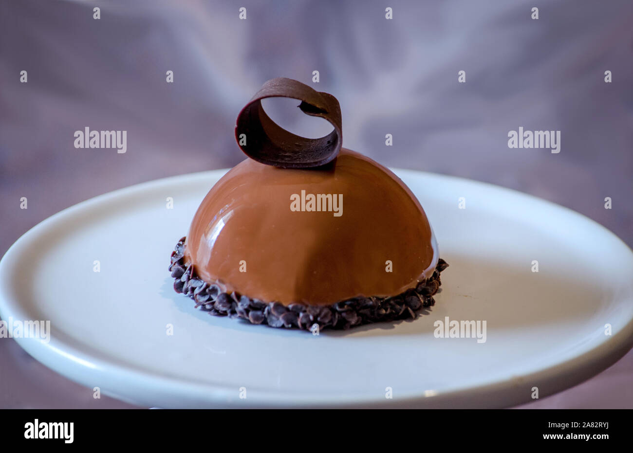 Délicieux gâteau au chocolat avec une souris chocolat curl, sur une plaque en céramique Banque D'Images