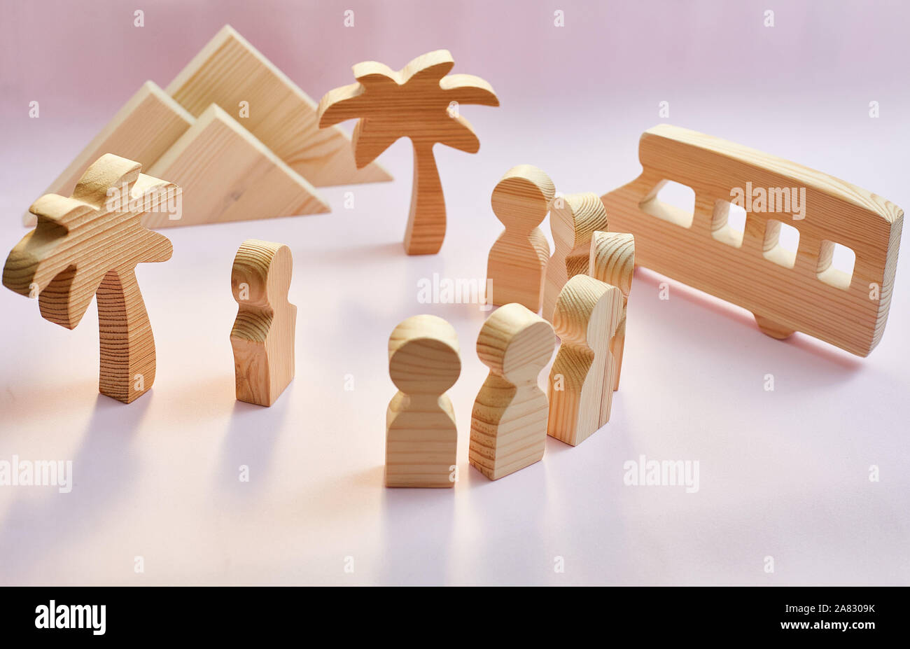 Concept d'excursion. figures en bois de personnes, palmiers, montagnes, bus Banque D'Images
