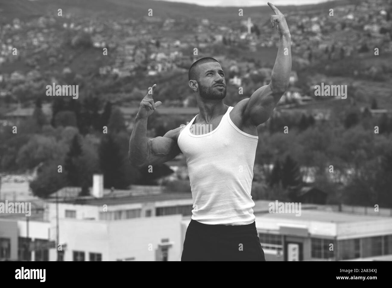 Portrait d'un jeune homme en bonne forme physique montrant son corps bien formé - Athletic musculaire Fitness Model Posing Bodybuilder exercices après l'extérieur Banque D'Images