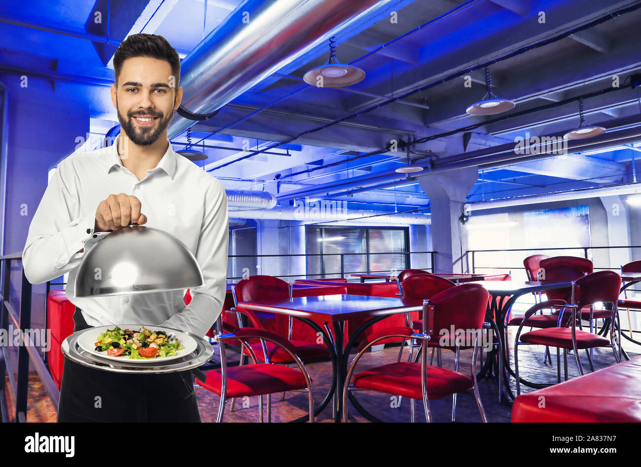 Handsome waiter avec salade fraîche au café moderne Banque D'Images
