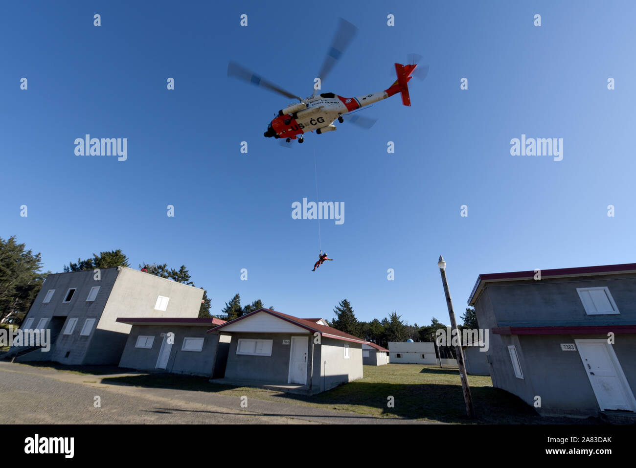 Maître de 3e classe Bryan Evans, un des techniciens de l'aviation au secteur de la Garde côtière canadienne, du fleuve Columbia est abaissé d'un hélicoptère Jayhawk MH-60 sur le toit de la simulation d'une maison au Camp Rilea les opérations militaires en territoire urbain Village de Warrenton, Ore., le 1 novembre, 2019. Cette formation a été conçu pour répondre aux besoins des équipages aériens en milieu urbain les opérations de recherche et sauvetage, à la suite de la rétroaction des membres de répondre aux grandes catastrophes naturelles dans le passé. (U.S. Photo de la Garde côtière canadienne par le maître de 3e classe Trevor Lilburn) Banque D'Images