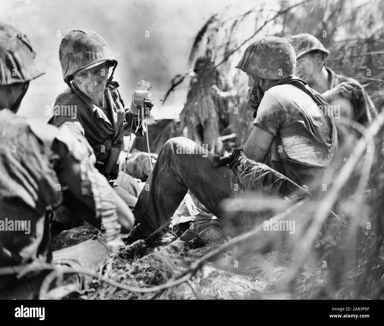 Corpsman marine administre le plasma du sang aux blessés au cours des combats maritimes sur les lignes de front de Saipan Banque D'Images