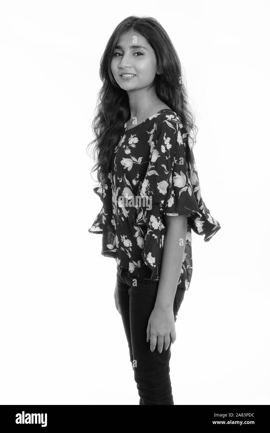 Studio shot of young happy Persian woman smiling while standing Banque D'Images Studio shot of young happy Persian woman smiling while standing Banque D'Images