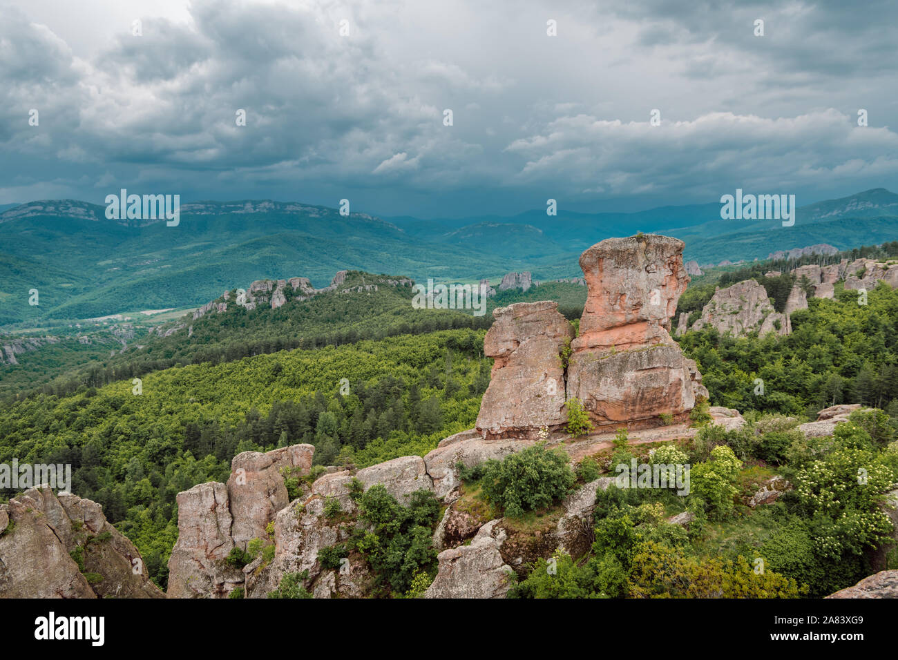 Ciel orageux sur de belles formations rocheuses. Avec leur couleur rouge ils opposent magnifiquement avec les forêts vertes, Belogradchik roches, la Bulgarie. Banque D'Images