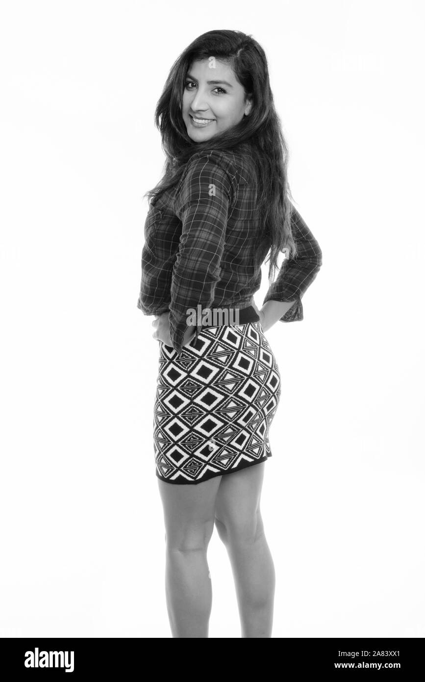 Studio shot of young woman smiling persan heureux tout en se posant et regarde en arrière Banque D'Images