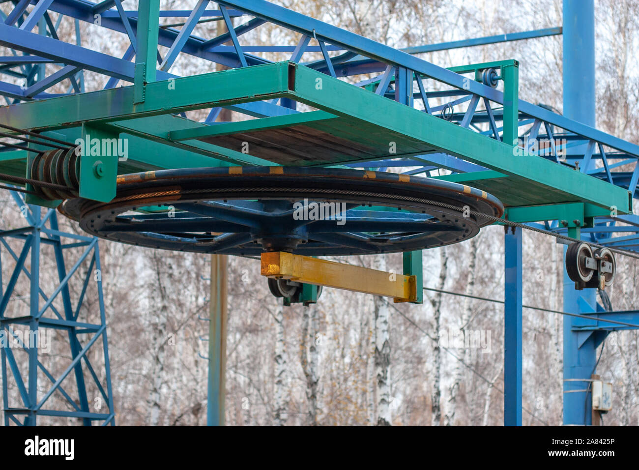 La grande roue du système de rouleau avec les câbles de remontées mécaniques de près. Les arbres flous sur l'arrière-plan. Banque D'Images