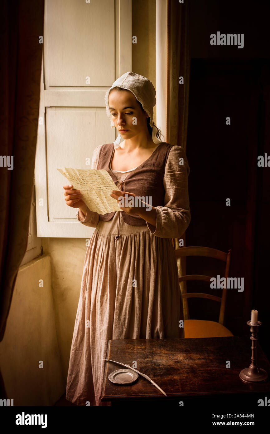 Style Vermeer portrait d'une jeune femme en costume renaissance la lecture d'une lettre à sa fenêtre Banque D'Images