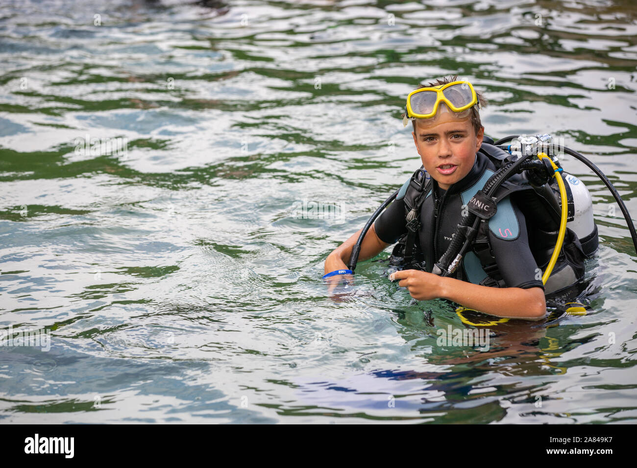 Un jeune garçon portant un costume de plongée dans l'eau. Banque D'Images