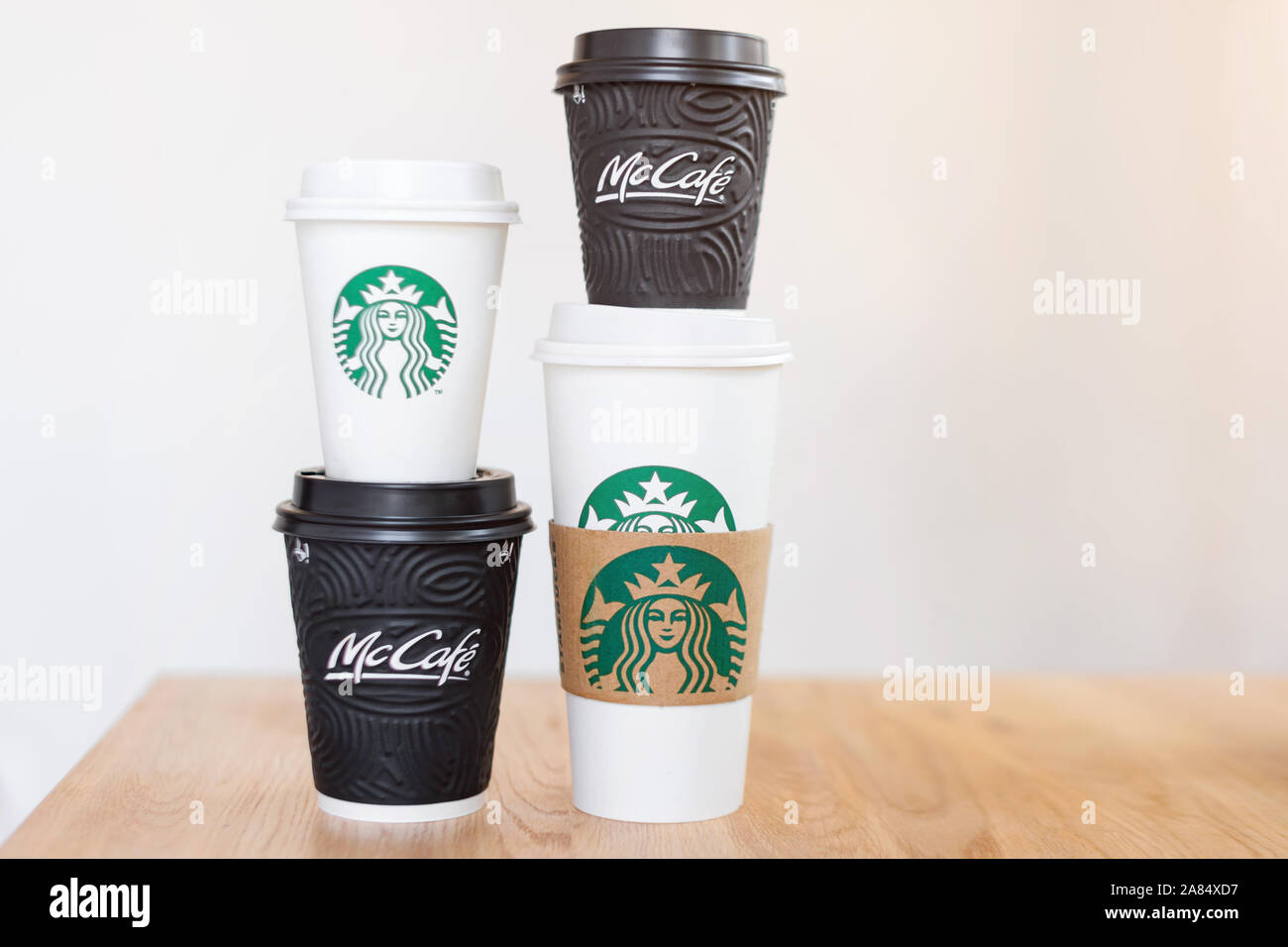 KIEV, UKRAINE / Novembre 06, 2019 : quatre tasses de café Starbucks et McDonald's café sur table en bois sur fond clair. La confrontation de la marque Banque D'Images